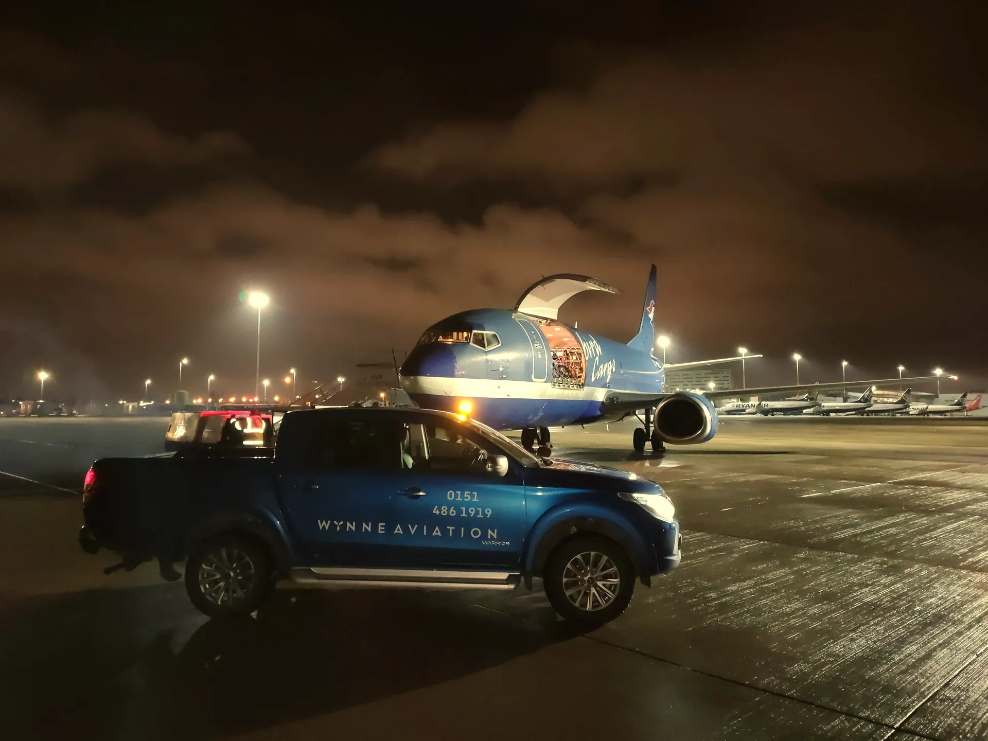 Wynne Aviation pickup beside a freighter on a night turnaround